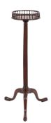 A George III mahogany circular torchere: with a baluster turned brass inlaid galleried top,