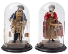 A pair of early 19th Century pedlar dolls: she in bonnet and red cloak, her wares include a lantern,