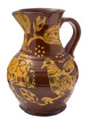 A late 18th Century slipware baluster jug: decorated in cream slip on the brown ground with birds,
