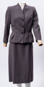 A lady's grey two piece suit:, together with a green evening dress by Carnegie of London,