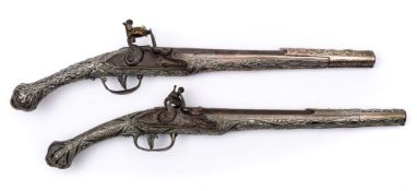 A matched pair of 18th Century Continental silver mounted flintlock pistols:, unsigned,