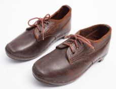 A pair of early 20th century child's brown leather clogs.