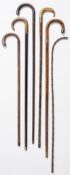 A group of five various silver mounted walking sticks: together with a horn handled gilt mounted