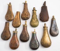 A collection of various copper and brass powder flasks:, all unsigned,