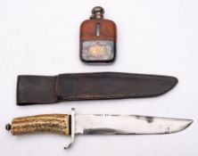 A Bowie style knife:, unsigned with simulated stag horn grip in a black leather scabbard,
