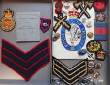 A collection of assorted military items: including cloth badges, stripes, cap badges,