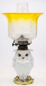 A French porcelain zoomorphic lamp: in the form of an owl on a rustic mound base with brass mounts,