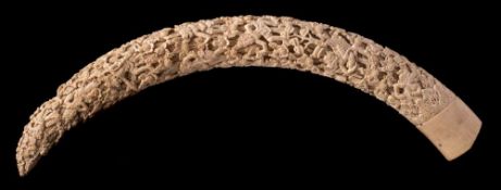 A large 19th Century fully carved Indian tusk: decorated in deep relief depicting demons being