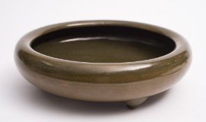 A Chinese tea-dust glazed tripod bowl: of squat circular form with rolled rim, 27cm diameter.