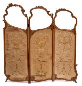A French carved walnut and embroidered panel three fold graduated screen:,