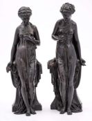 A pair of late 19th Century bronze figures: of neo-classical females draped in robes and leaning
