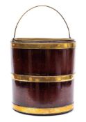 A George III mahogany and brass bound bucket: of cylindrical form with brass loop carrying handle