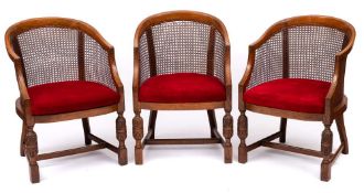 A 1930's carved oak dining suite: decorated with fruiting vines comprising a set of six tub-shaped