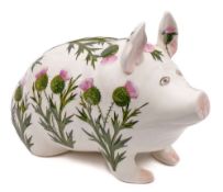A Plichta pottery pig: modelled in seated position and decorated with flowering thistles,
