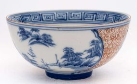 A Chinese copper red and underglaze blue bowl: painted with two cartouches depicting lake