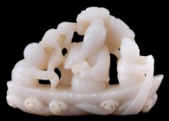 A Chinese carved jade group: of three figures seated in a boat, pine trees in the background, 11cm.