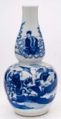 A Chinese blue and white double gourd vase: painted with an equestrian figure and attendants,