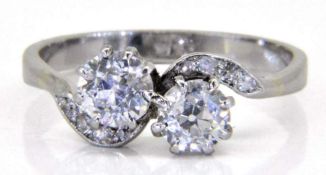 A diamond two-stone cross-over ring: with round old, brilliant-cut diamonds, 5.2mm diameter x 3.