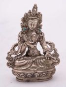 A small Tibetan silver Buddha: wearing ornate headdress and turquoise inlaid earrings,