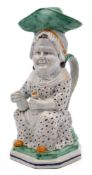 A late 18th century Prattware 'Martha Gunn' toby jug and cover: modelled seated and wearing a large