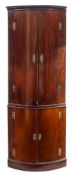 A mahogany bow-fronted standing corner cupboard:, in two sections,