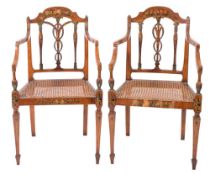 A set of four Sheraton period satinwood and decorated elbow chairs:, painted with floral foliage,