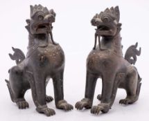 A pair of Burmese bronze mythical beasts: with engraved and inlaid decoration, 19 cm.