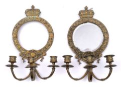 A pair of brass three-branch girandole mirrors: each circular backplate surmounted by a crown,