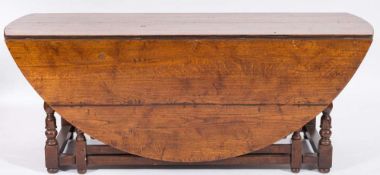 An oak double gateleg action dining table: of large size in the 18th Century taste with a circular