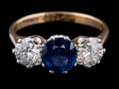 A sapphire and diamond three-stone ring: the oval sapphire approximately 6.8mm long x 6.