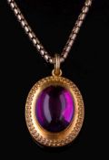 A Victorian gold and cabochon amethyst pendant locket on chain: with central oval cabochon amethyst