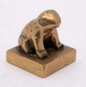 A Chinese polished bronze seal: with a seated toad surmount and four seal script characters to the