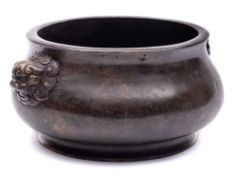 A Chinese bronze censer: of compressed circular form on an everted foot with finely cast opposing