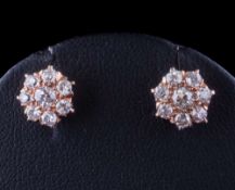 A pair of diamond mounted circular cluster ear-studs: with round brilliant-cut diamonds estimated