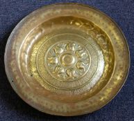 A Nuremberg brass alms dish: with central embossed decoration enclosed by two borders of script,