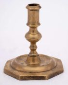 A 17th Century Spanish brass candlestick: with plain cylindrical nozzle on a knopped stem and domed