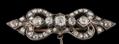 A Victorian white metal and diamond mounted bar brooch: of pierced design set with old,