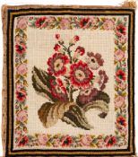A 19th Century woolwork panel: depicting a floral spray enclosed by a Berlin work foliate border,