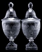 A pair of Georgian-style cut glass urns and covers: the domed covers with faceted finials,