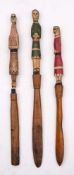 Three folk art carved wood stick dolls, possibly American: with polychrome decoration,