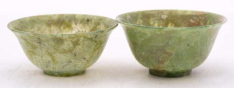 Two Chinese jadeite bowls: each with flared rim, the translucent celadon coloured stone with cream,