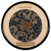 A Chinese silk dragon roundel: embroidered with two dragons encircling a central peony spray on a