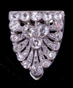 A diamond clip brooch: of stylised anthemion shell design millegrain and pave-set with round old
