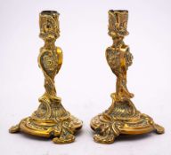 A pair of early 19th Century gilt brass candlesticks: in the rococo taste,