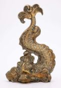 A late Georgian brass doorstop: depicting a stylized dolphin of curved design,