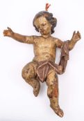 A Continental carved wood and polychrome decorated putto: draped with a robe over outstretched arms,