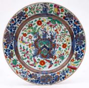 A large Chinese porcelain armorial charger: painted in underglaze blue with the arms and crest of