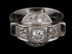 An Art Deco diamond mounted cluster ring: mille-grain-set with a central round brilliant-cut