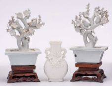 A pair of Chinese blanc de chine blossom tree ornaments and a similar small vase: two birds perched