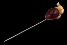 A 19th Century cabochon garnet and fox motif mounted stick pin: the pear-shaped cabochon garnet